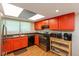 Functional kitchen featuring bright orange cabinets, modern appliances, and ample counter space, plus window view at 4965 Hawthorne Way, Avon, IN 46123