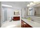 Bright bathroom boasting double vanities, a glass block shower, and a skylight providing natural light at 5108 Riverview Dr, Indianapolis, IN 46208