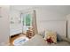 Comfortable bedroom boasts hardwood floors, a white bed frame, and a bright window with a view of trees at 5108 Riverview Dr, Indianapolis, IN 46208