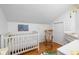Bright Bedroom with hardwood floors features a white crib, changing table, and wooden rocking chair at 5108 Riverview Dr, Indianapolis, IN 46208