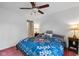 Cozy bedroom showcases a floral comforter, ceiling fan, and hardwood floors, creating a comfortable and inviting space at 5108 Riverview Dr, Indianapolis, IN 46208