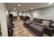 Basement entertaining space features a sectional couch, and dining area, next to a workout and storage area at 537 N 17Th St, Noblesville, IN 46060