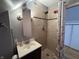 Bathroom featuring a stand up shower with stone tile, rainfall shower head, and granite sink at 537 N 17Th St, Noblesville, IN 46060