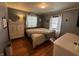 Bedroom featuring hardwood floors, neutral tones, and a bright window with sheer curtains at 537 N 17Th St, Noblesville, IN 46060