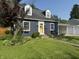 Charming blue house with a yellow door, dormer windows, and well-maintained landscaping at 537 N 17Th St, Noblesville, IN 46060