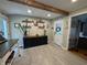 Open kitchen area with dark cabinets, wooden beam, floating shelves and view of the backyard at 537 N 17Th St, Noblesville, IN 46060