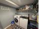 Bright laundry room with modern appliances, open storage shelves, and hardwood laminate flooring at 537 N 17Th St, Noblesville, IN 46060