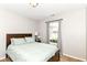 Cozy bedroom featuring a window, wooden headboard, and neutral walls at 5651 Pine Knoll Blvd, Noblesville, IN 46062