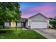 Charming single-story home with attached garage and front lawn at dusk at 5651 Pine Knoll Blvd, Noblesville, IN 46062