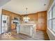 Modern kitchen with wood cabinets, stainless steel appliances, a central island, and bright windows at 5651 Pine Knoll Blvd, Noblesville, IN 46062