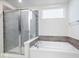 Modern bathroom showcasing a glass-enclosed shower and a luxurious soaking tub at 5655 Lighthouse Dr, Brownsburg, IN 46112
