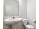 Clean half-bathroom with pedestal sink, white toilet, and minimalist design, creating a neat space at 5655 Lighthouse Dr, Brownsburg, IN 46112