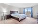 Cozy bedroom featuring a queen bed, bedside table with lamp, and large window with curtains at 5655 Lighthouse Dr, Brownsburg, IN 46112
