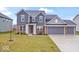 Charming two-story home with brick and siding, a manicured lawn, and a three-car garage at 5655 Lighthouse Dr, Brownsburg, IN 46112