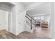 Bright hallway with hardwood floors leading to a carpeted staircase, providing access to the upper level of the home at 5655 Lighthouse Dr, Brownsburg, IN 46112