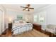 Comfortable bedroom featuring hardwood floors, shutters, and a cozy seating area at 5681 Carrollton Ave, Indianapolis, IN 46220