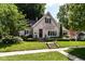 Charming brick home with professionally landscaped front yard and mature trees at 5681 Carrollton Ave, Indianapolis, IN 46220