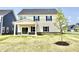 New two-story home featuring a covered patio, sliding glass doors, and newly planted tree at 581 Roosevelt St, Fortville, IN 46040