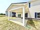 New construction home featuring a covered patio with stone accents and a grassy backyard at 581 Roosevelt St, Fortville, IN 46040