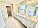 Bathroom featuring double sinks, tile flooring, framed mirrors, and open access to the walk-in closet at 581 Roosevelt St, Fortville, IN 46040