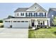 Charming two-story home featuring a two-car garage, well-manicured lawn, and inviting front porch at 581 Roosevelt St, Fortville, IN 46040