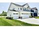 Spacious two-story home featuring a three-car garage, green lawn, and attractive architectural details at 581 Roosevelt St, Fortville, IN 46040
