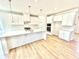 Well-lit kitchen featuring white cabinets, a large island, and stainless steel appliances at 581 Roosevelt St, Fortville, IN 46040