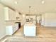 Modern kitchen with white cabinetry, quartz countertops, and a central island with a sink at 581 Roosevelt St, Fortville, IN 46040