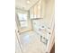 Bright laundry room featuring tile flooring, utility sink, white cabinets, and a window for natural light at 581 Roosevelt St, Fortville, IN 46040