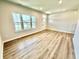 Inviting living room featuring hardwood floors, large windows, neutral walls, and ample natural light at 581 Roosevelt St, Fortville, IN 46040