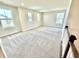 This loft area has carpeted flooring, neutral walls, and multiple windows for ample light at 581 Roosevelt St, Fortville, IN 46040
