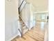 Elegant staircase with wood and carpet steps leading to an open-concept living space and hardwood floors at 581 Roosevelt St, Fortville, IN 46040