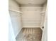 Bright walk-in closet with carpeted floors and wire shelving for optimal storage in a new construction home at 581 Roosevelt St, Fortville, IN 46040