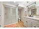 Charming bathroom featuring a glass-door shower and a modern vanity with a decorative mirror and sink at 6045 Haverford Ave, Indianapolis, IN 46220
