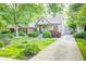Charming home showcasing lush greenery, flowering plants, and a welcoming front yard at 6045 Haverford Ave, Indianapolis, IN 46220
