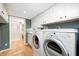 Bright laundry area with washer, dryer, and views into an attached bathroom with a toilet and shower at 6045 Haverford Ave, Indianapolis, IN 46220