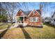 Lovely brick home with manicured lawn, covered porch, and mature trees in a serene setting at 6640 E Washington St, Indianapolis, IN 46219