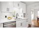 Well-lit kitchen featuring white cabinets, subway tile backsplash, and stainless steel dishwasher at 6640 E Washington St, Indianapolis, IN 46219