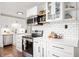 Beautifully renovated kitchen with white cabinets, stainless steel appliances, and subway tile backsplash at 6640 E Washington St, Indianapolis, IN 46219