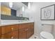 Bathroom showcasing a wood vanity with chrome hardware, white countertop, and modern wall decor at 6704 Hoover Rd, Indianapolis, IN 46260
