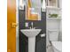 Stylish powder room featuring a pedestal sink, modern fixtures, and dark walls at 6704 Hoover Rd, Indianapolis, IN 46260