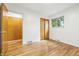 Bright bedroom featuring hardwood floors, a window, and closet with bi-fold doors at 6704 Hoover Rd, Indianapolis, IN 46260