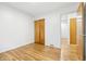 Bedroom with hardwood floors, closet with wood doors, and doorway to another room at 6704 Hoover Rd, Indianapolis, IN 46260