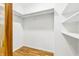 Bright, empty closet with wood floor, shelves, and a hanging rod for organized storage at 6704 Hoover Rd, Indianapolis, IN 46260