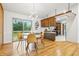 Bright dining area with wood floors and an open layout leading to the kitchen and a sliding glass door to the deck at 6704 Hoover Rd, Indianapolis, IN 46260