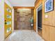 Stylish entryway featuring a yellow front door, accent cork wall, decorative tile floors and natural wood elements at 6704 Hoover Rd, Indianapolis, IN 46260
