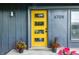 Close up of the eye-catching yellow front door with black hardware, potted red flowers and the house number at 6704 Hoover Rd, Indianapolis, IN 46260