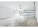 Spacious garage with high ceilings, overhead door, and a window for natural light at 6704 Hoover Rd, Indianapolis, IN 46260