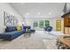 Inviting living room with cone fireplace, a plush blue sectional sofa, modern accent chair, and ample natural light at 6704 Hoover Rd, Indianapolis, IN 46260