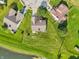 Aerial view showcasing a neighborhood with green lawns and mature trees near a cul-de-sac and a pond at 7456 Jack Pine Ct, Avon, IN 46123